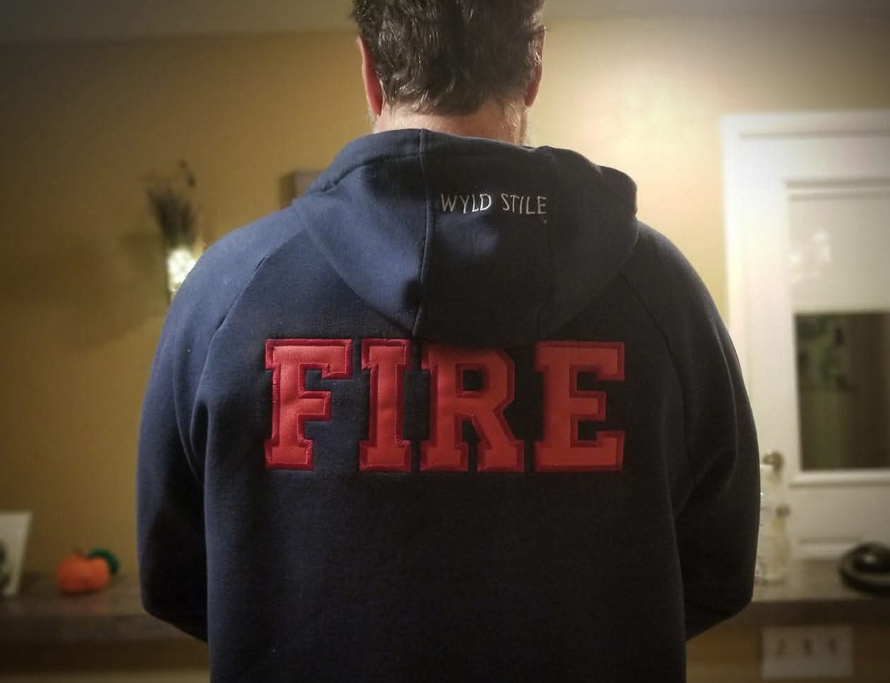 A navy hooded sweatshirt with large embroidered block letters across the shoulders, made by Independence Embroidery in Owensville, Missouri.