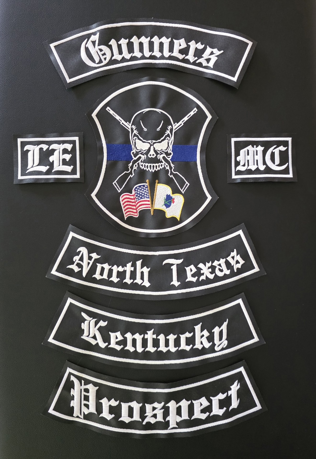 A full five-part set of embroidered law enforcement motorcycle club colors with three curved rocker patches below, made by Independence Embroidery in Owensville, Missouri.