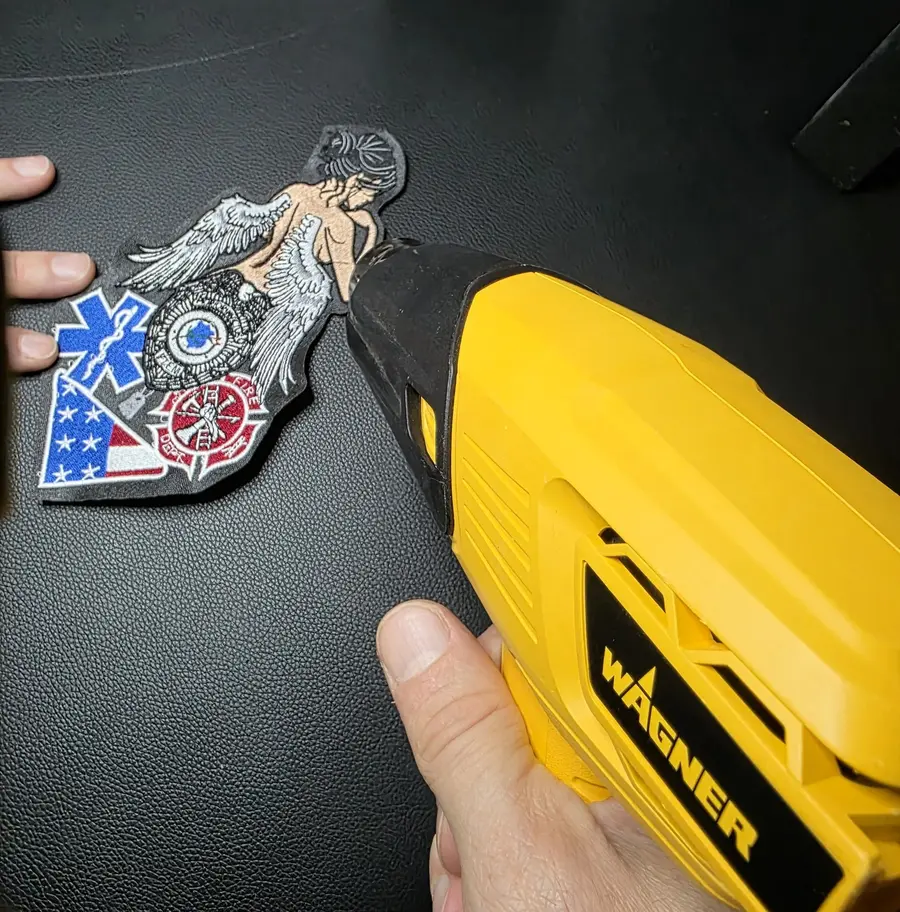 A heat gun aimed at the freshly cut edge of an embroidered patch, at Independence Embroidery in Owensville, Missouri.
