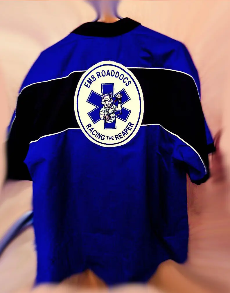 A blue and black shirt with a large embroidered emblem across the back, made by Independence Embroidery in Owensville, Missouri.