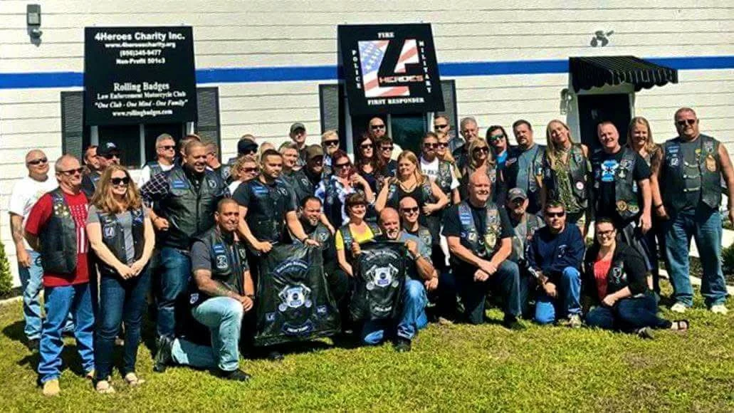 A large group of motorcycle club members in embroidered colors standing outside a charity building, patches by Independence Embroidery in Owensville, Missouri.