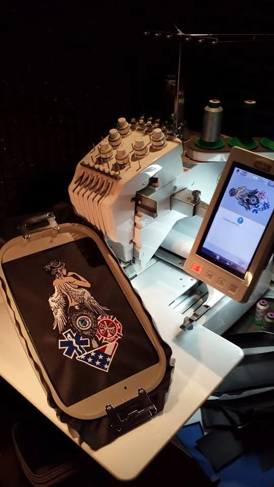 A patch hooped on the embroidery machine mid-stitch in Owensville, Missouri.